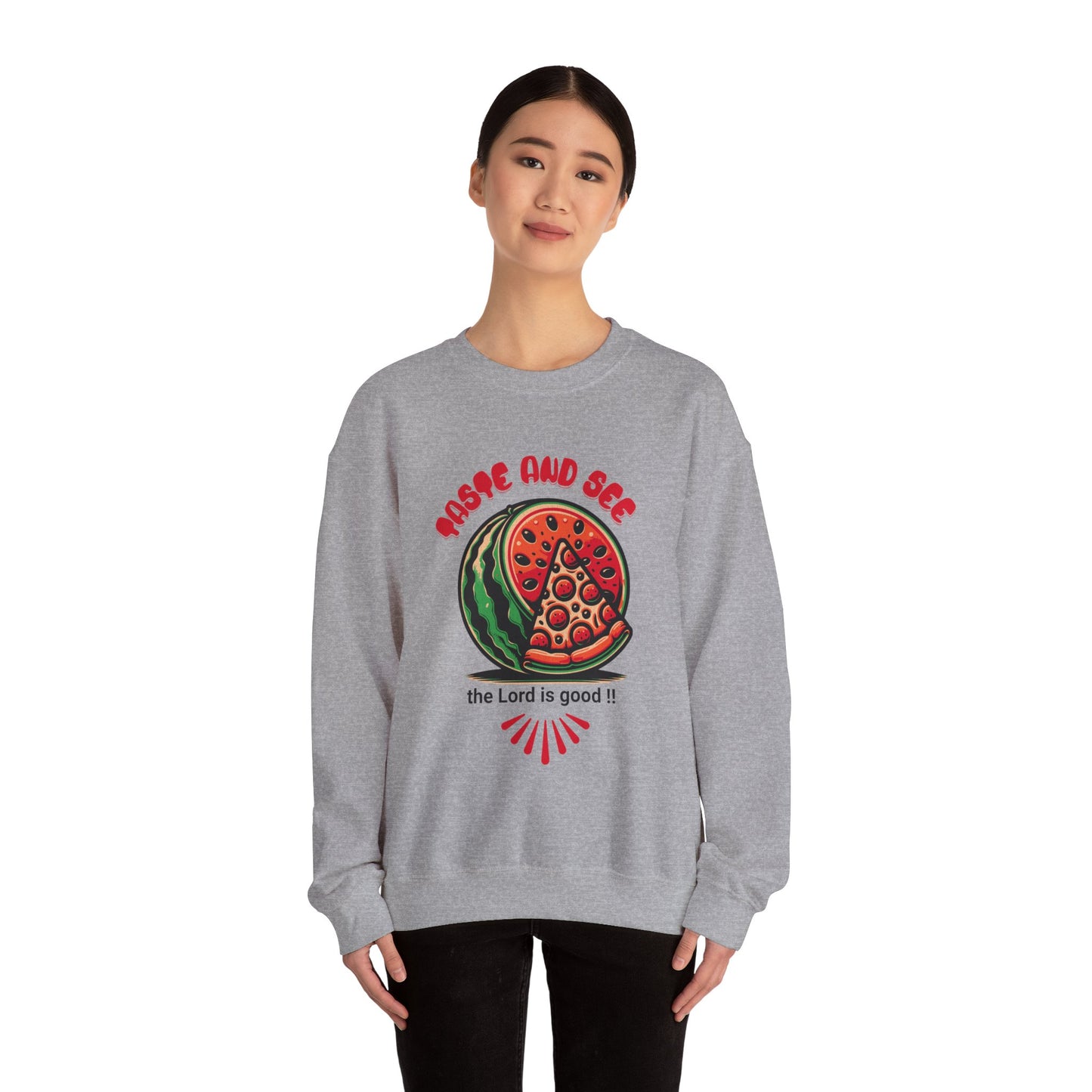 Model wearing gray crewneck jumper with Christian message 'Taste and See the Lord is Good' and bold food-themed artwork. Comfortable religious wear.