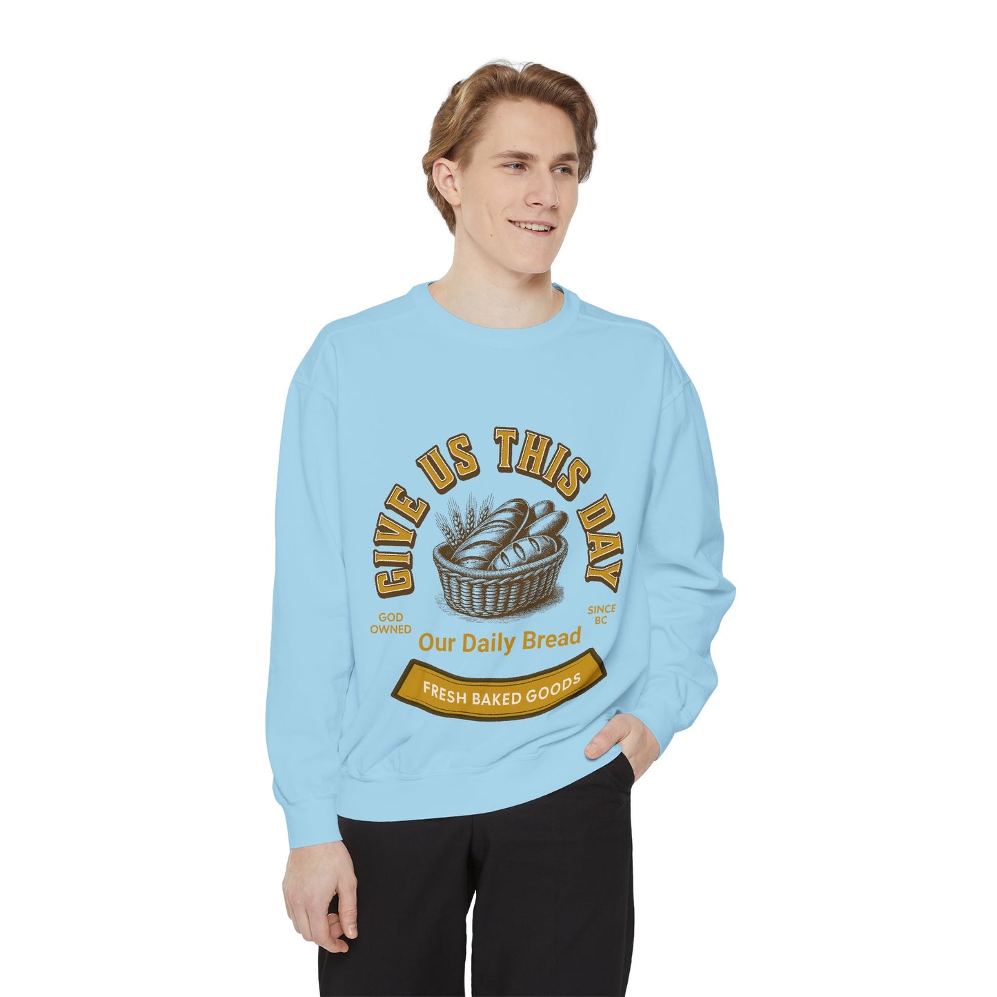 Model in light blue Inspirational Crewneck Sweatshirt with 'Give us this Day Our Daily Bread' and bread basket graphic. Cozy Christian-themed top.