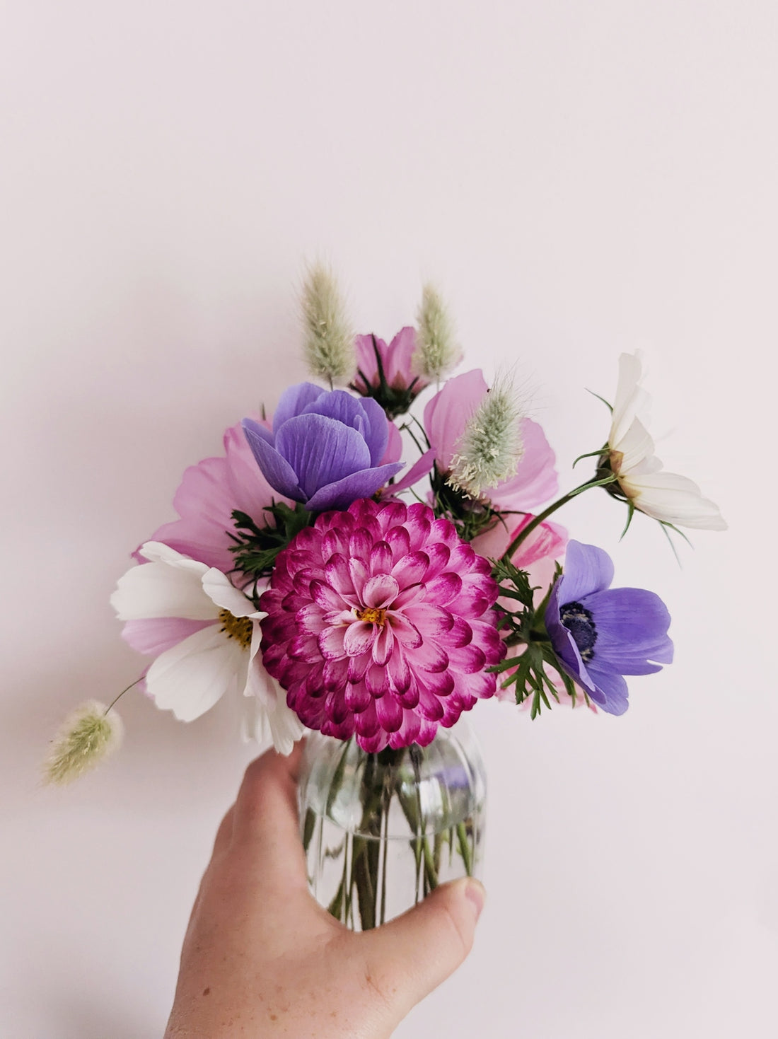 Vibrant flowers arranged in a small glass vase.