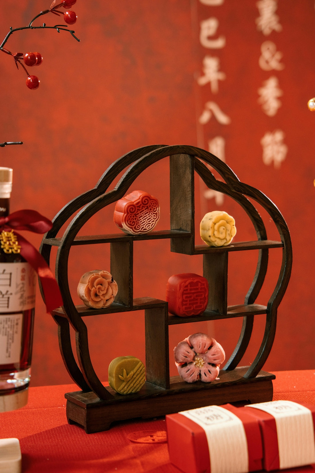 Assortment of decorative mooncakes on a wooden display stand.