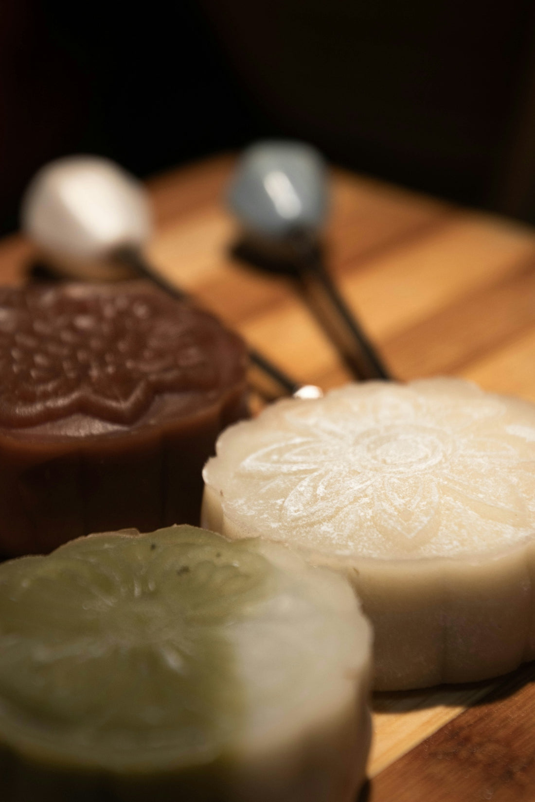 Three colorful mooncakes arranged on a wooden board.