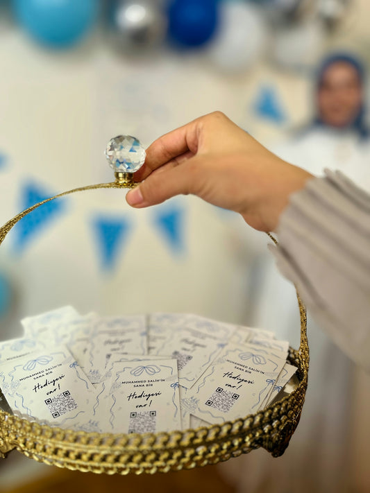 Hand holding basket of small cards with qr codes.