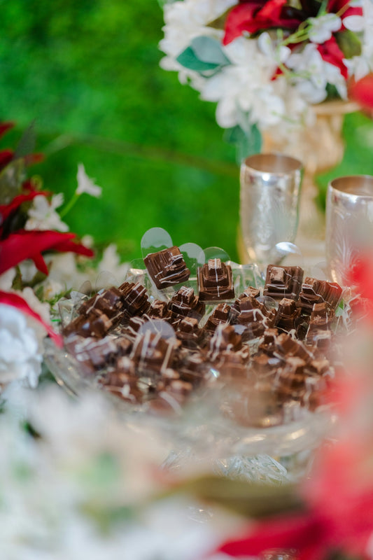 A pile of decorative chocolates on a glass plate.
