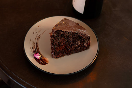 A slice of rich chocolate cake on a decorative plate.
