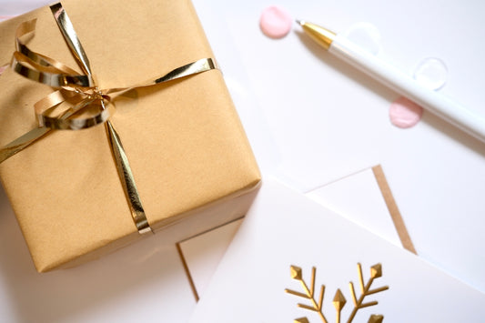 Gift wrapped in gold ribbon with holiday cards.