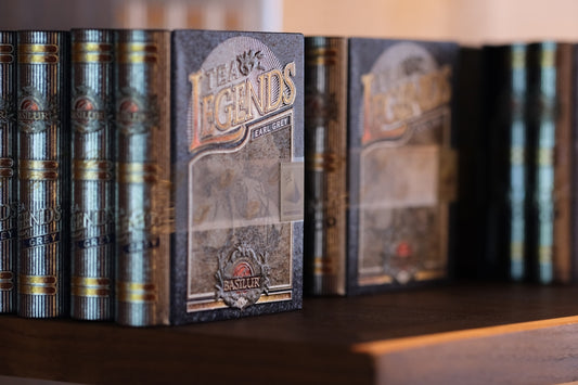 Row of vintage books on a wooden shelf.