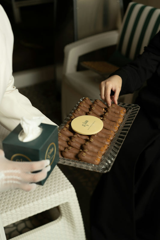 Hands offering and taking dates from a serving tray