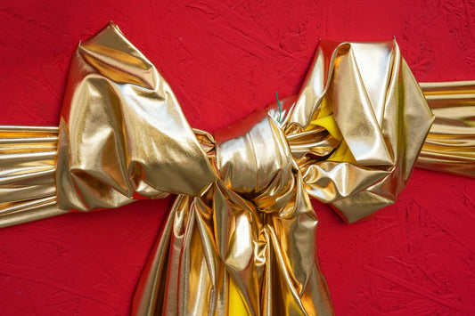 A shiny golden bow on a red background