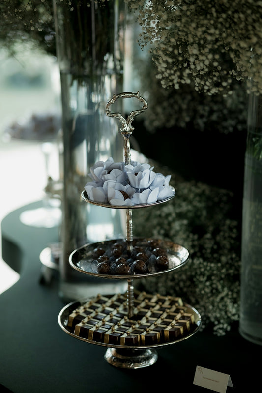 Three-tiered silver stand with assorted chocolates and candies