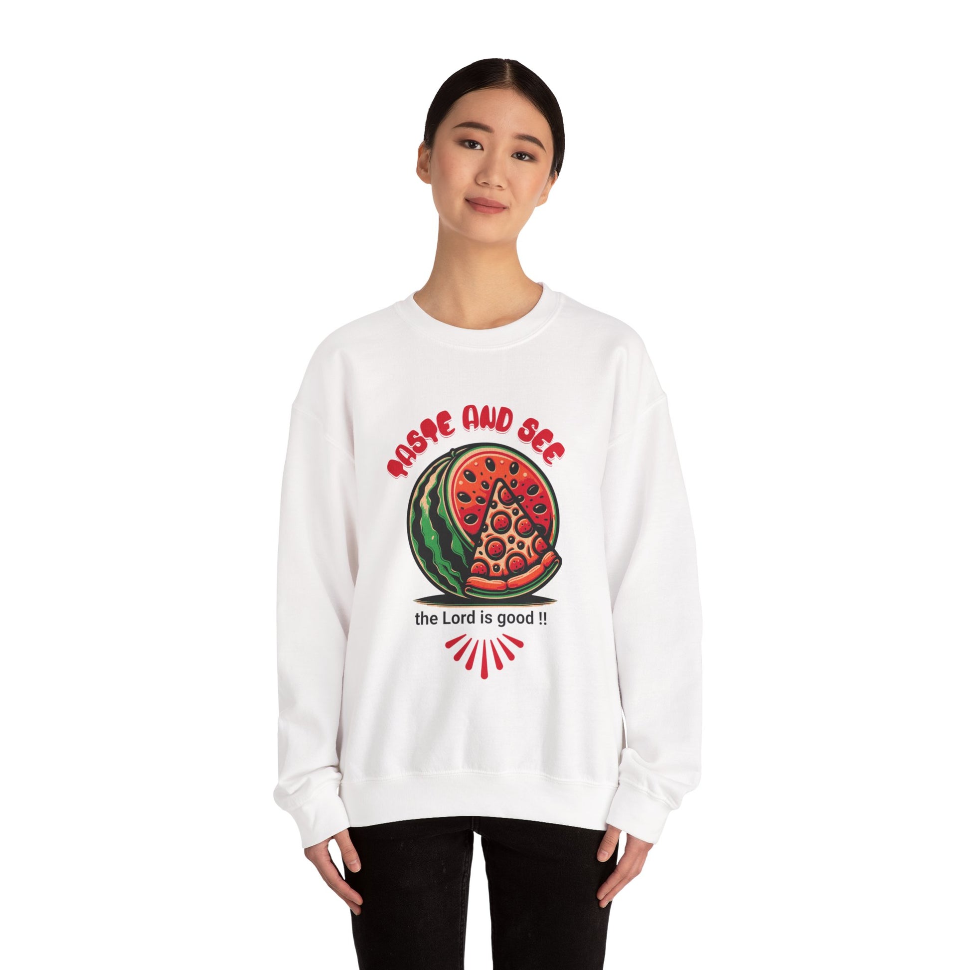 Model wearing white inspirational crewneck sweatshirt with 'Taste and See the Lord is Good' message and vibrant food design. Cozy religious apparel.