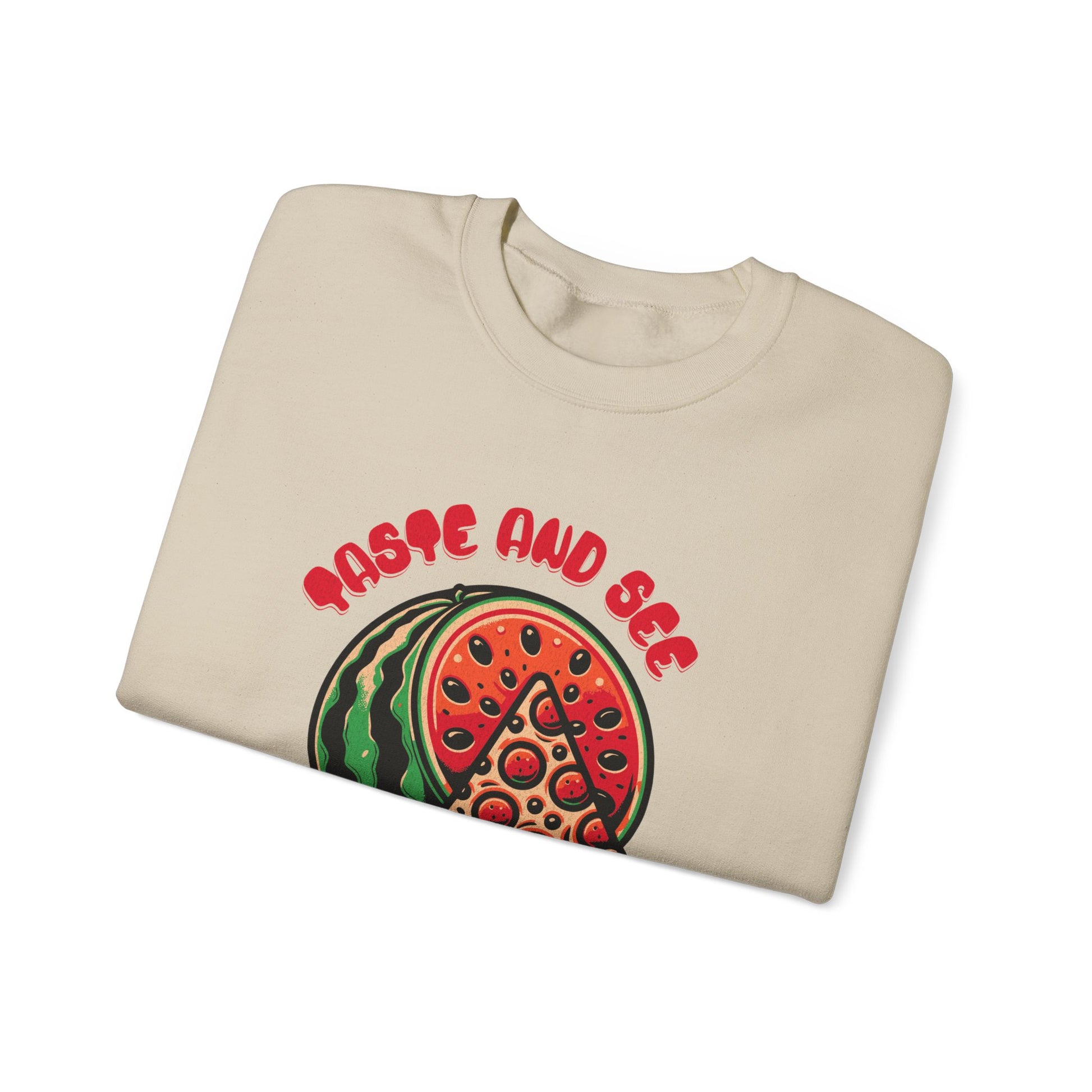Folded beige sweatshirt with Christian quote 'Taste and See the Lord is Good' and unique watermelon-pizza graphic. Great faith-based gift.